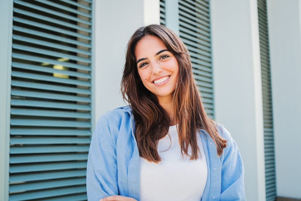 Woman in blue shirt folding arms